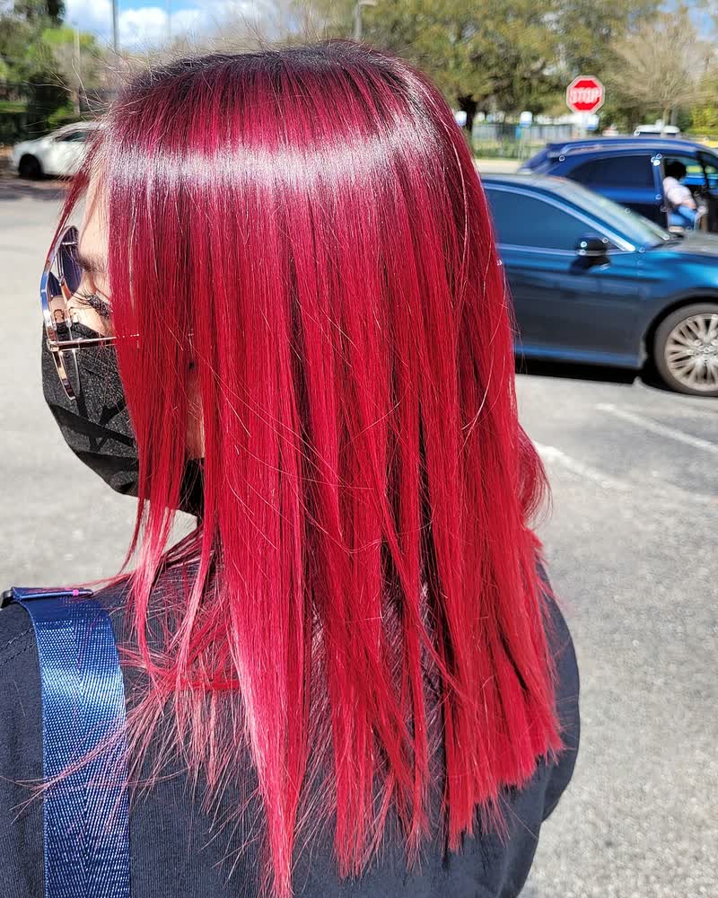Vivid magenta-red hair color on straight, shoulder-length hair at Will Vazquez Beauty Bar, Orlando