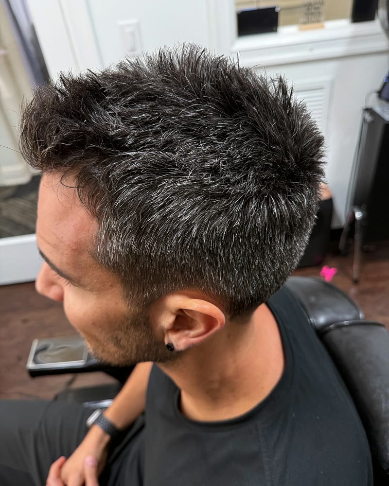 Short, textured men's haircut on salt-and-pepper hair with tapered sides at Will Vazquez Beauty Bar, Orlando