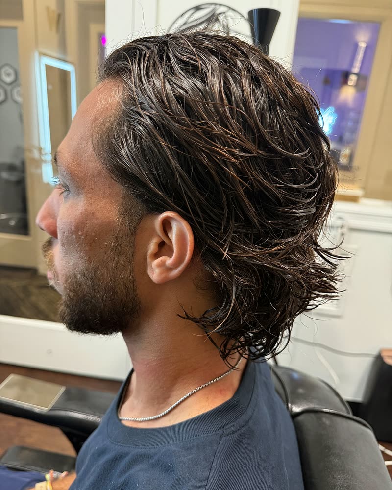 Medium-length layered men's cut on wavy dark hair, styled back at Will Vazquez Beauty Bar, Orlando